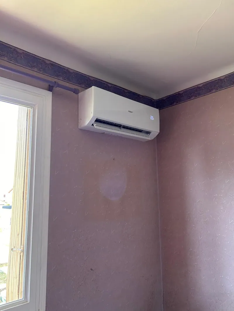 Climatiseur blanc sur un mur mauve